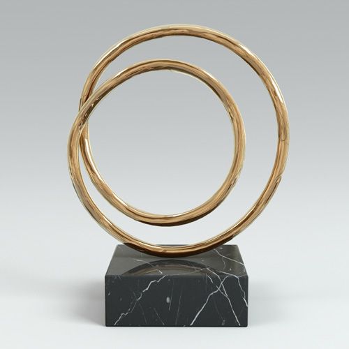 a marble base with three gold rings on it