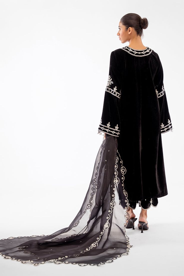 This classic silhouette is cut from lustrous black velvet and features detailed zardoze work. Gota tassels and scalloped hems on the trousers give this coord set a finished look. This outfit is paired with an eyelet embroidered organza dupatta. Black Evening Palazzo Set For Eid, Black Palazzo Set For Evening Eid, Black Palazzo Set For Evening Eid Festival, Festive Black Palazzo Set For Evening, Evening Kurta With Dupatta In Traditional Drape, Evening Palazzo Set With Sheer Dupatta For Eid, Palazzo Set With Dupatta For Evening Eid, Evening Palazzo Set With Dupatta For Eid, Eid Evening Palazzo Set With Dupatta