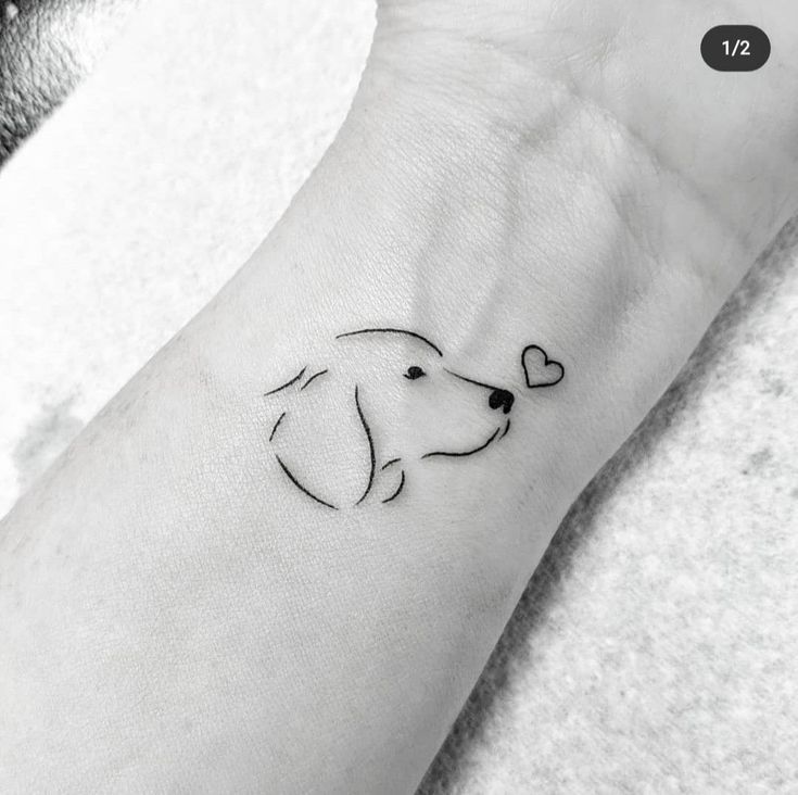 a black and white photo of a dog with a heart tattoo on its wrist