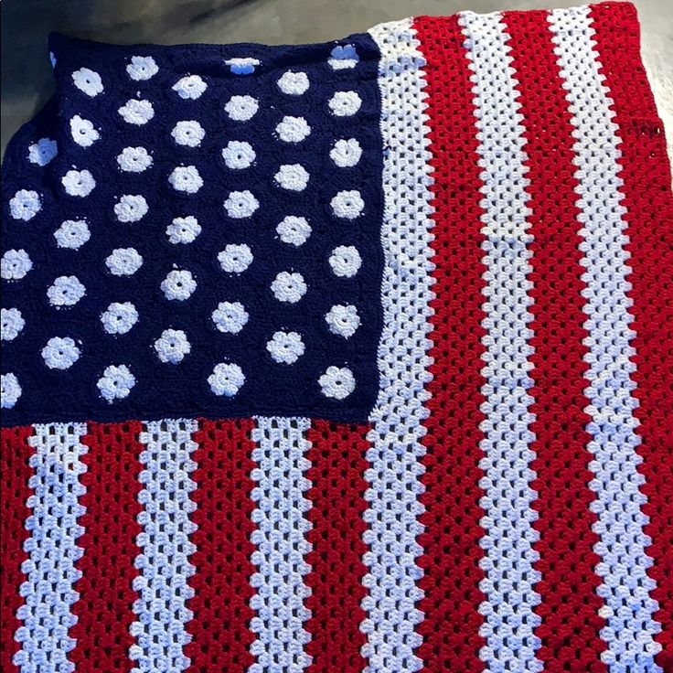 an american flag crocheted blanket with white flowers on it and a red, white, and blue afghan