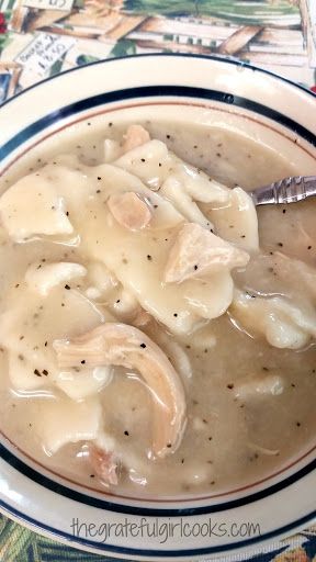 a bowl filled with dumplings and gravy on top of a table