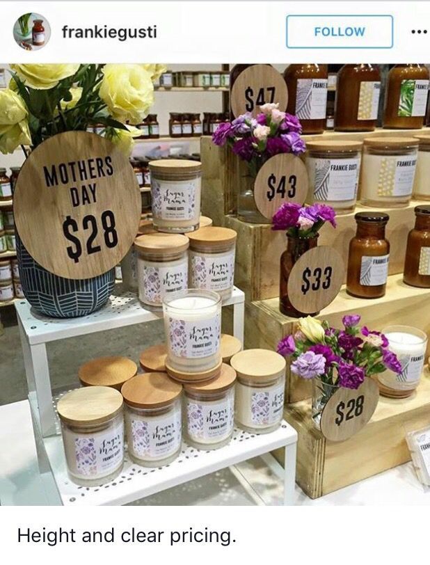 a display with jars and flowers in front of it for sale on the shelf at a store