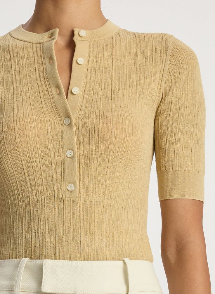 The Fisher Top is knitted from fine gauge cotton-blend yarn in a sandy beige hue. This round-neck silhouette features a button-down placket and 3/4 sleeves, lending a sporty and textural touch to any look. This style runs true to size. Shop Tops Styling Tip: Pair with everything from trousers to shorts. Half Sleeve Sweater, Loungewear Outfits, Office Siren, Shop Tops, Silk Knit, Heavy Knit, Knit Sleeve, Knitwear Tops, Knit Outfit