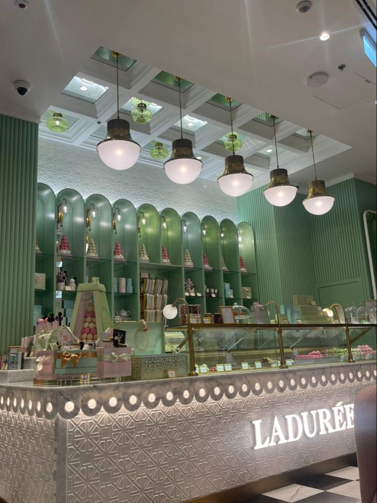 the interior of a store with green walls and lights