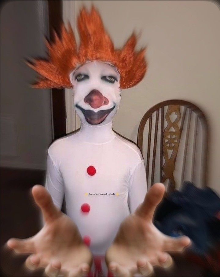 a creepy clown with red hair and white body is holding his hands out in front of him