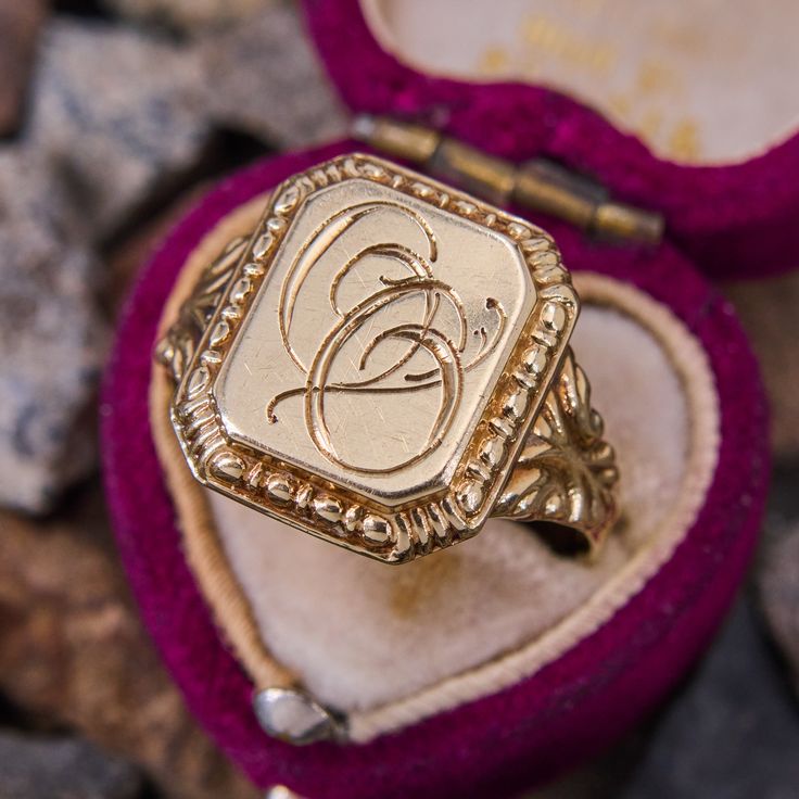 This antique signet ring features the initials "OO" in script on the rectangular shaped top. The shoulders are decorated with beautiful scrolling and patina. The ring is crafted in 14k yellow gold and is a size 10.5. We are not offering resizing due to the hand engraved inscription on the inside if the shank that reads "Minnie Fira Reidar de Wenke." Luxury Antique Signet Ring With Brilliant Cut, Luxury Vintage Diamond Cut Signet Ring, Luxury Engraved Victorian Signet Ring, Floral Signet Ring, Rectangular 14k Stamped Signet Ring Collectible, Signet Ring Initials, Heirloom Rectangular Signet Ring Stamped 14k, 14k Gold Engraved Ring With Initials For Collectors, 14k Gold Signet Ring With Maker's Mark As Gift