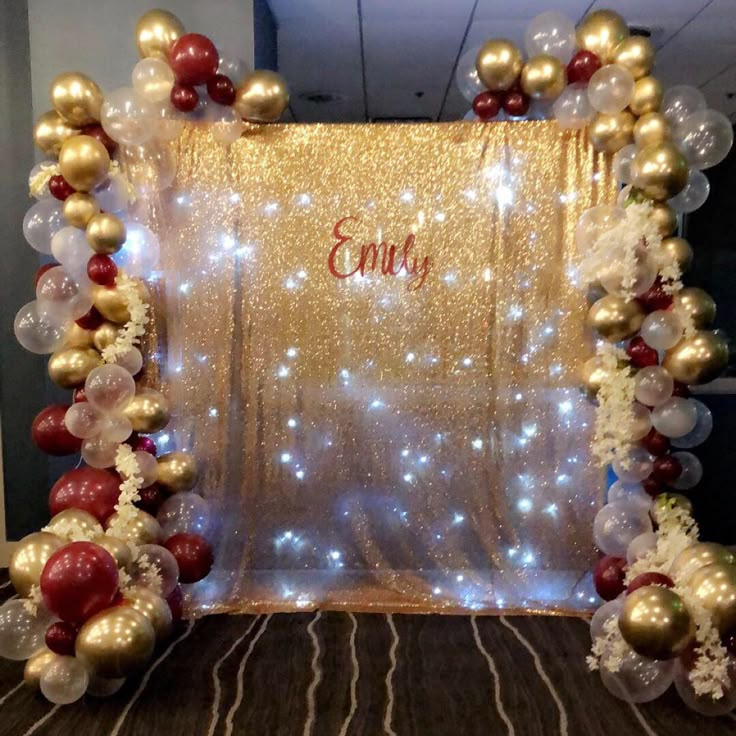 a photo frame decorated with balloons and streamers in red, white and gold colors