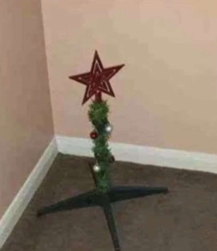 a christmas tree with red and green stars on it in the corner of a room