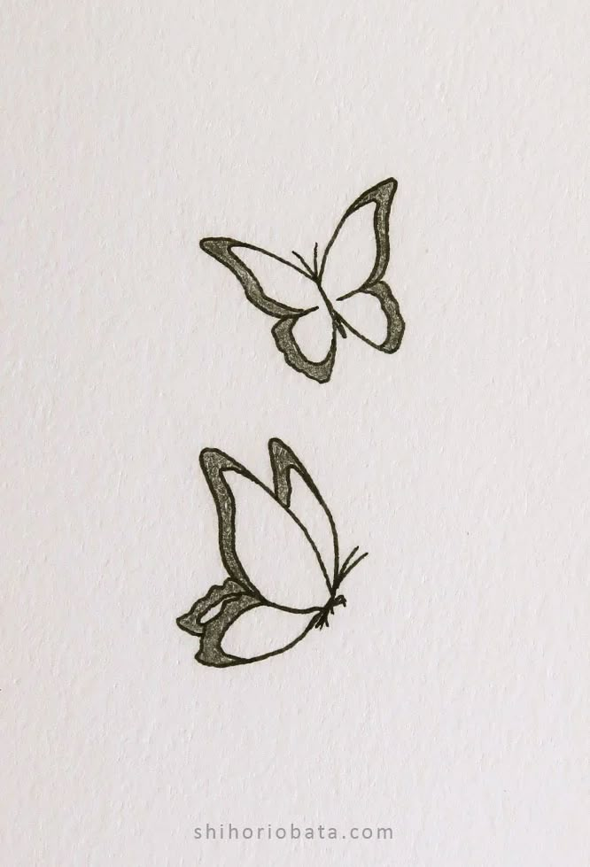 two butterflies flying in the air on top of a white paper sheet with black ink