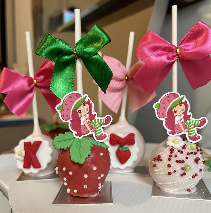 three chocolate covered strawberries with bows on them sitting in front of each other,