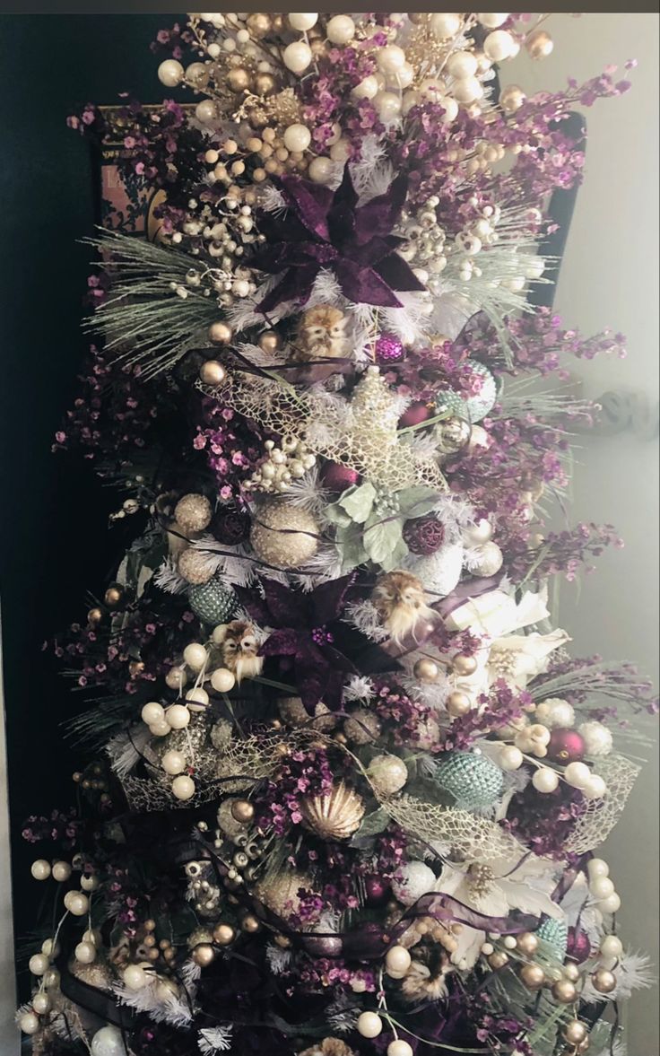 a christmas tree decorated with purple and white ornaments