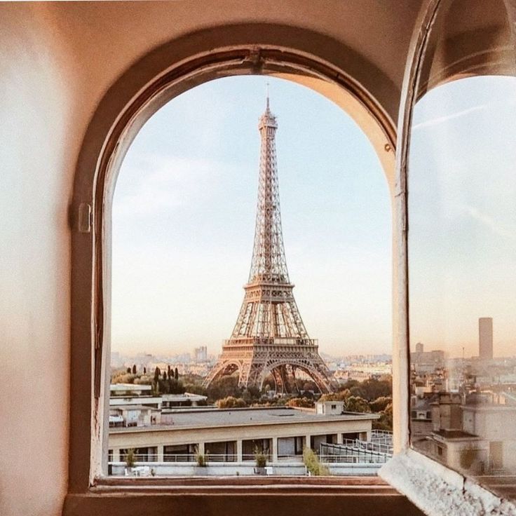 the eiffel tower is seen through an arched window