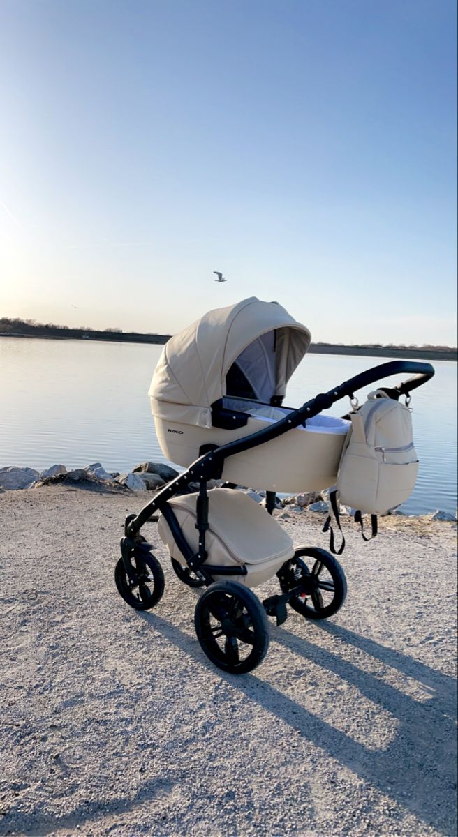 a baby stroller sitting on top of a sandy beach