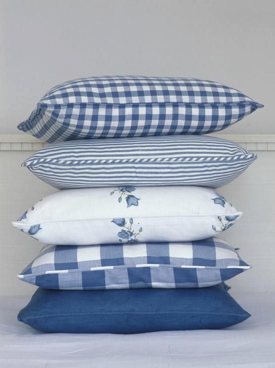 four pillows stacked on top of each other in front of a white wall and floor