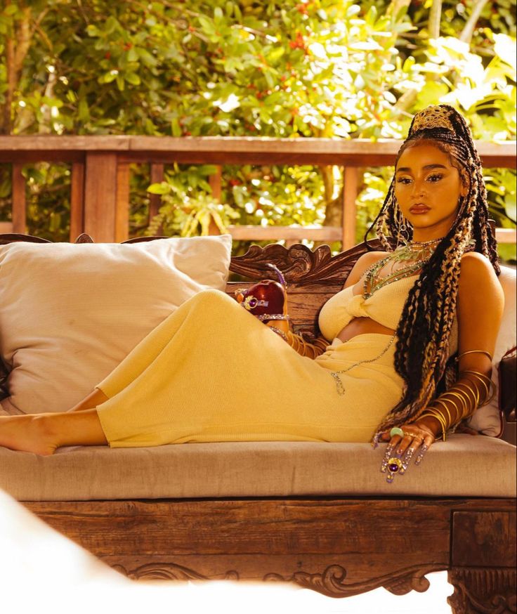 a woman sitting on top of a couch next to pillows