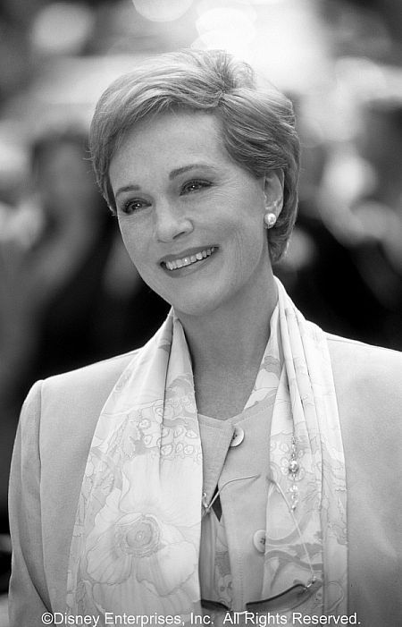 a black and white photo of a woman in a suit with a scarf around her neck