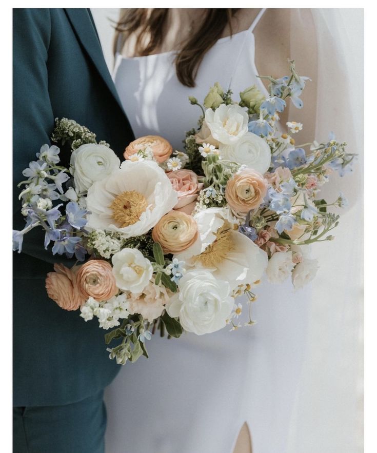 a bride and groom holding a bouquet of flowers