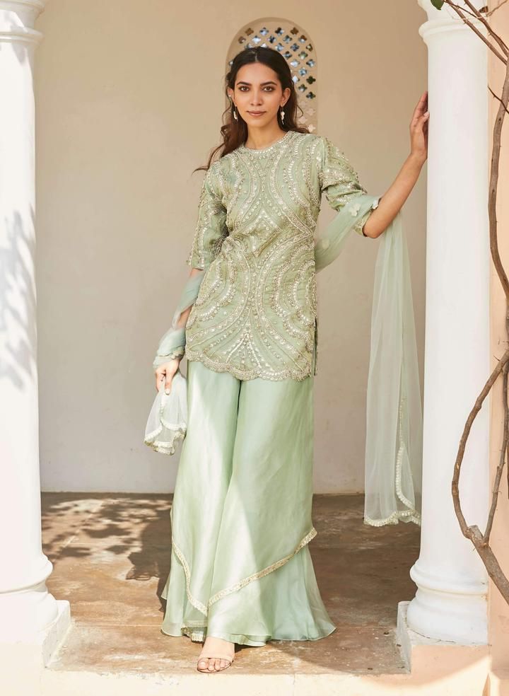 Editor's Note This Set Features Pastel Green Embroidered Silk Kurta, Sharara, And Dupatta Set Color: Pastel Green Fabric: Silk And Tissue Kora Dry Clean Only   About the Designer A melange of r... Sharara Suit Pastel Colors, Pastel Green Salwar Suit, Embroidered Raw Silk Palazzo Set With Traditional Drape, Embroidered Sharara With Straight Kurta For Reception, Embroidered Sharara For Reception With Straight Kurta, Embroidered Raw Silk Palazzo Set, Embroidered Pista Green Palazzo Set, Embroidered Raw Silk Palazzo Set For Reception, Embroidered Green Palazzo Set In Traditional Drape