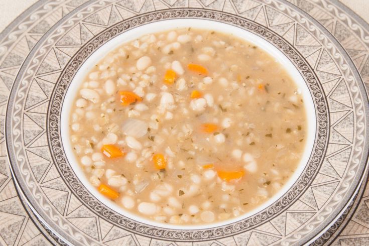 a white bowl filled with beans and carrots