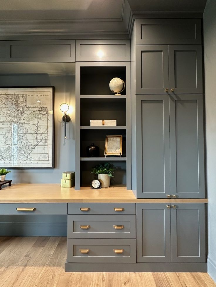 an office with gray cabinets and wood floors, along with a map on the wall