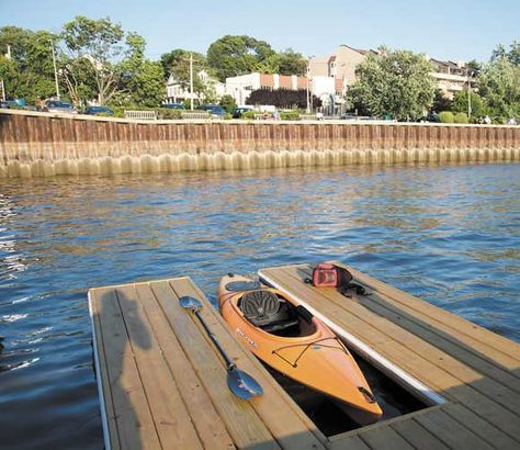 an orange kayak sitting on top of a wooden dock next to a body of water