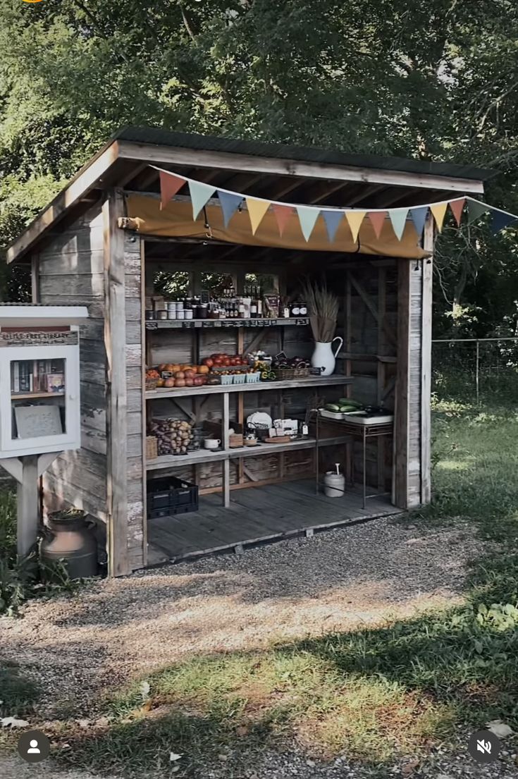 an outhouse is set up in the middle of a field with flags and bunting