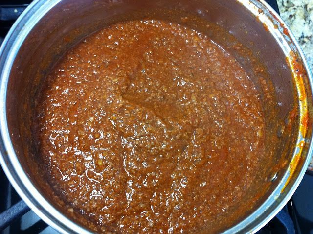 a pot filled with some kind of sauce on top of a stove burner,