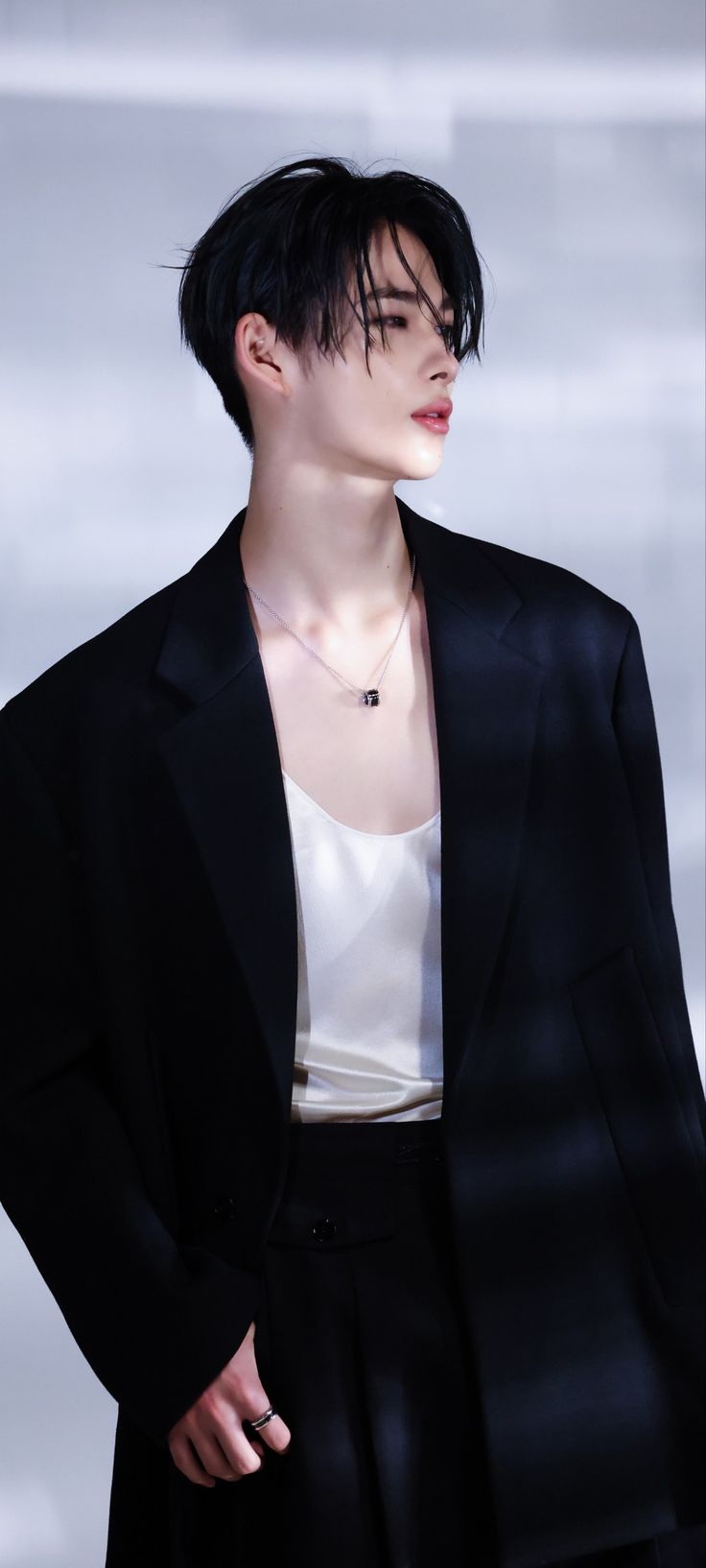 a woman with short black hair wearing a suit