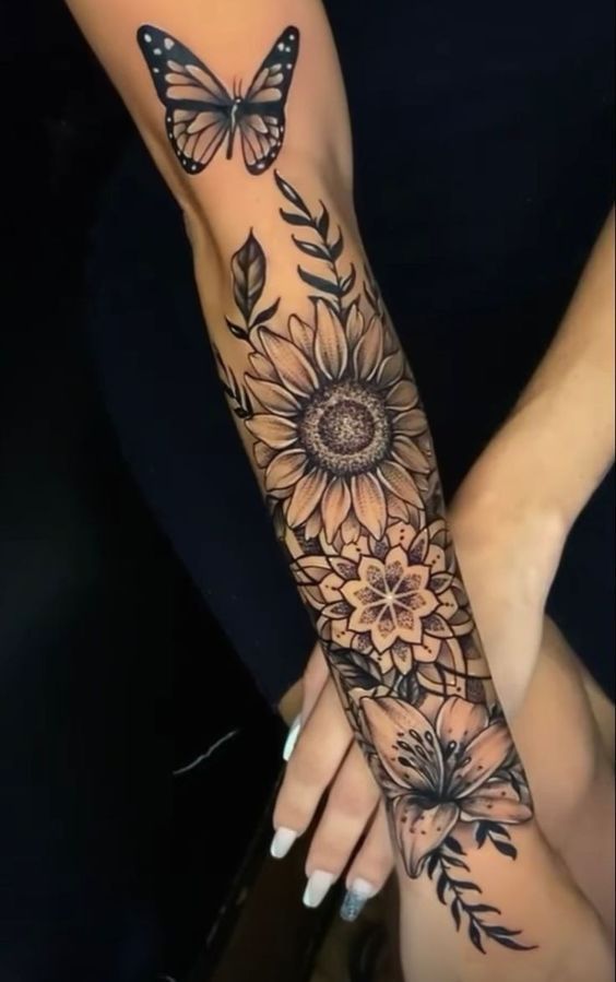 a woman's arm with sunflowers and butterflies on it