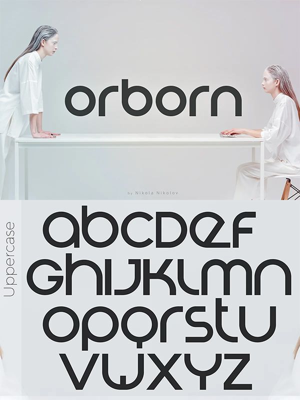 two women sitting at a table in front of an alphabet