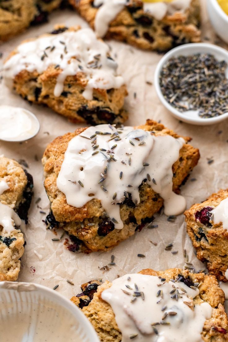 blueberry scones with white icing on parchment paper