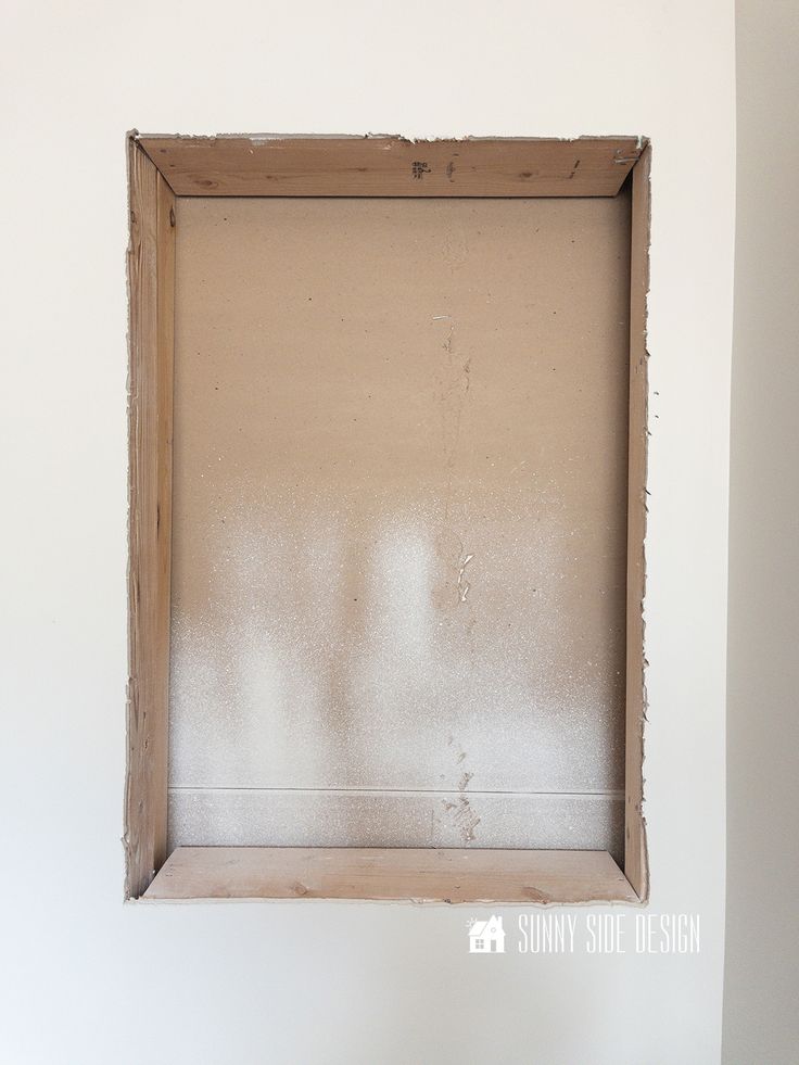 an empty wooden frame hanging on the wall