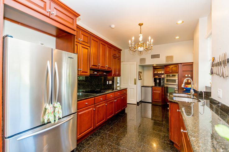 a kitchen with granite counter tops and stainless steel appliances, along with wooden cabinetry