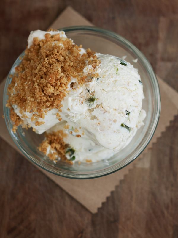 a bowl filled with whipped cream and toppings on top of a wooden table next to a napkin