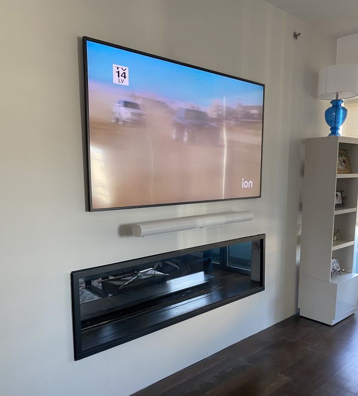 a flat screen tv mounted to the side of a wall above a fireplace in a living room