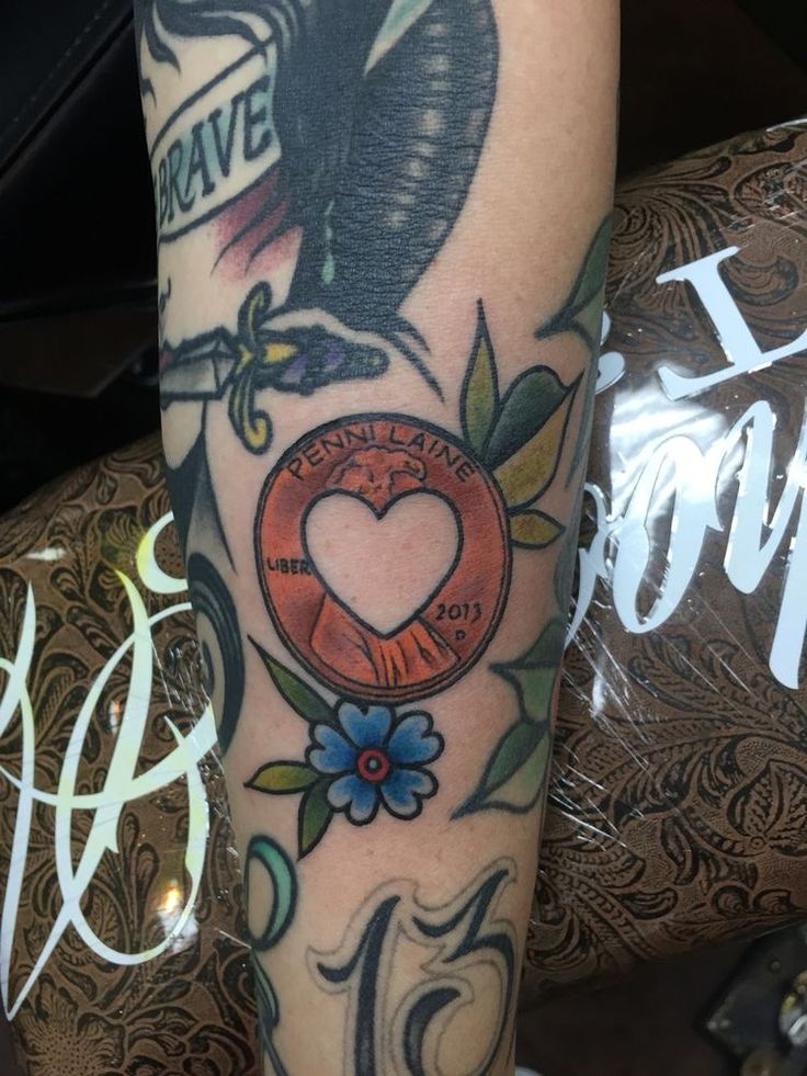 an arm with tattoos on it that says love is in the air and a heart