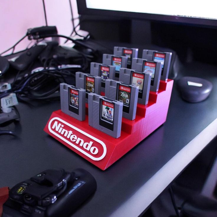 a bunch of nintendo gameboy's sitting on a desk next to a computer