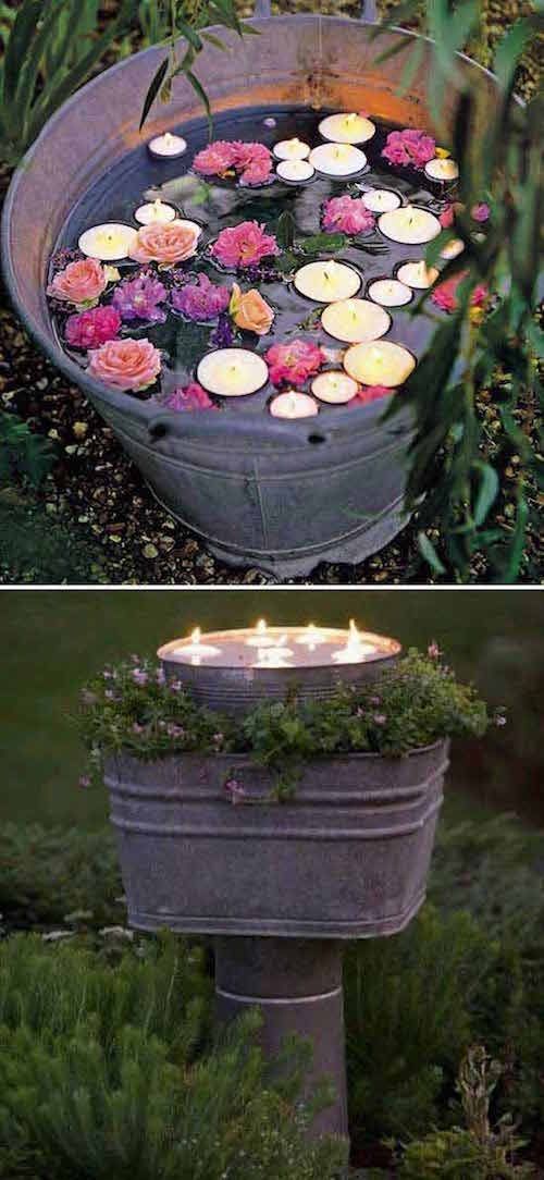 an outdoor fountain with candles in it and flowers floating on the water at each end