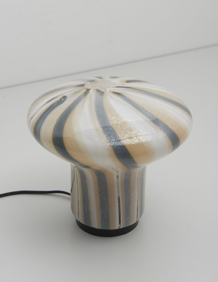 a white and black striped lamp sitting on top of a table