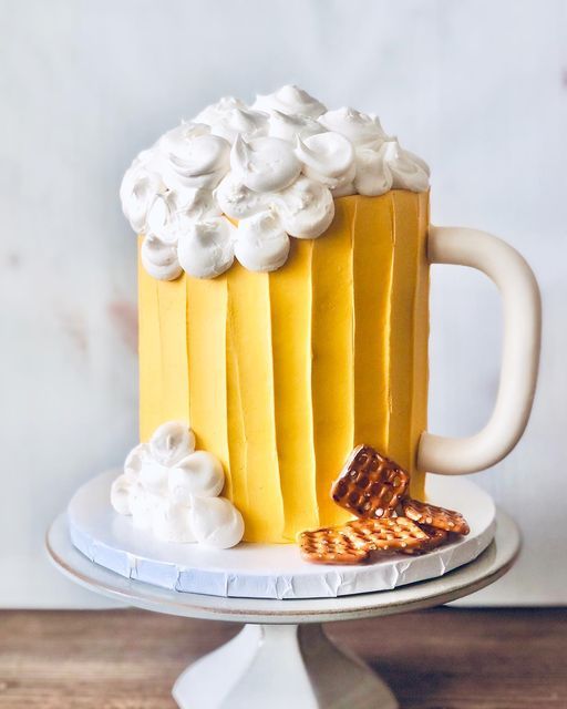 there is a cake that looks like a beer mug with whipped cream on top