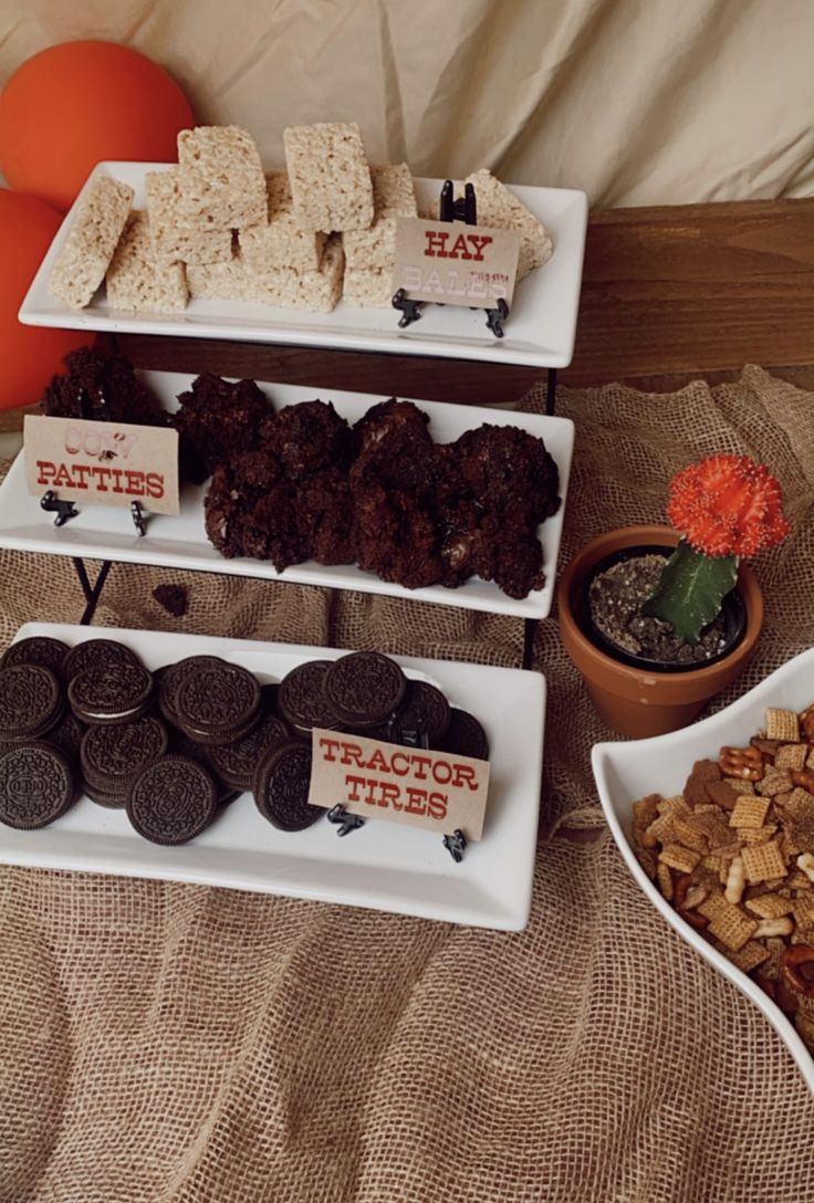 desserts and snacks are displayed on trays on a bed