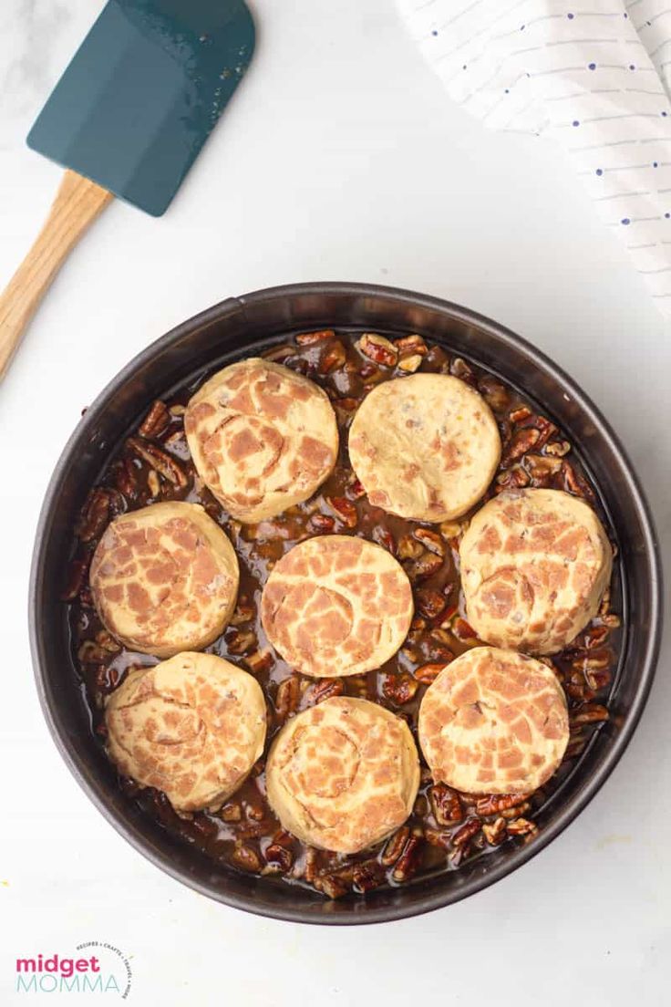 a pan filled with food next to a spatula on top of a white table