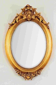 an ornate gold framed mirror hanging on the wall