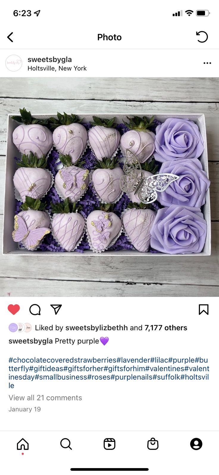 a box filled with lots of purple flowers on top of a wooden table next to an instagram post