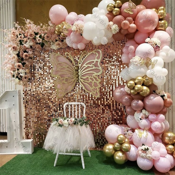 a chair sitting in front of a wall with balloons and flowers on the back ground