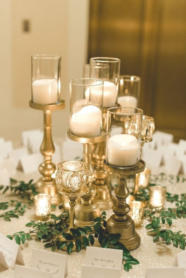 a table topped with lots of candles and place cards