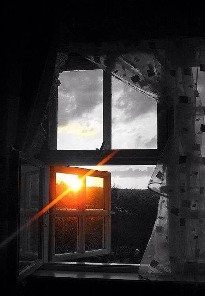 the sun is setting through an open window