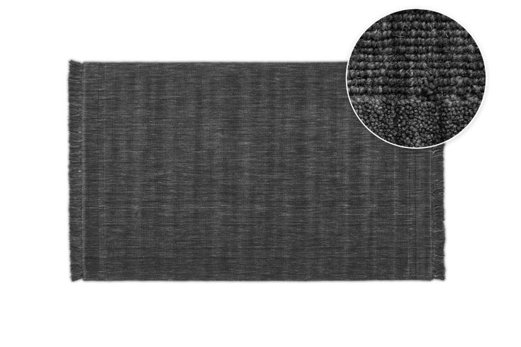 the dark gray rug is shown with a white background and an area for it to be used