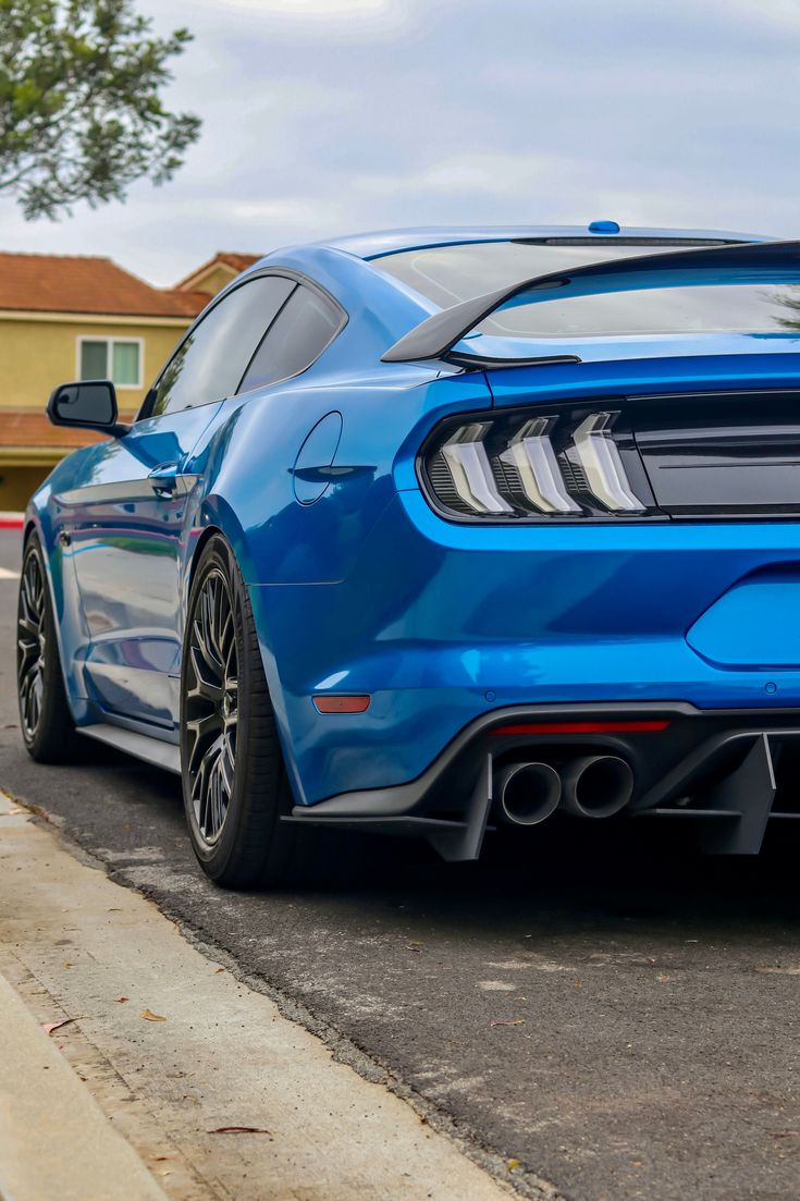 the rear end of a blue ford mustang