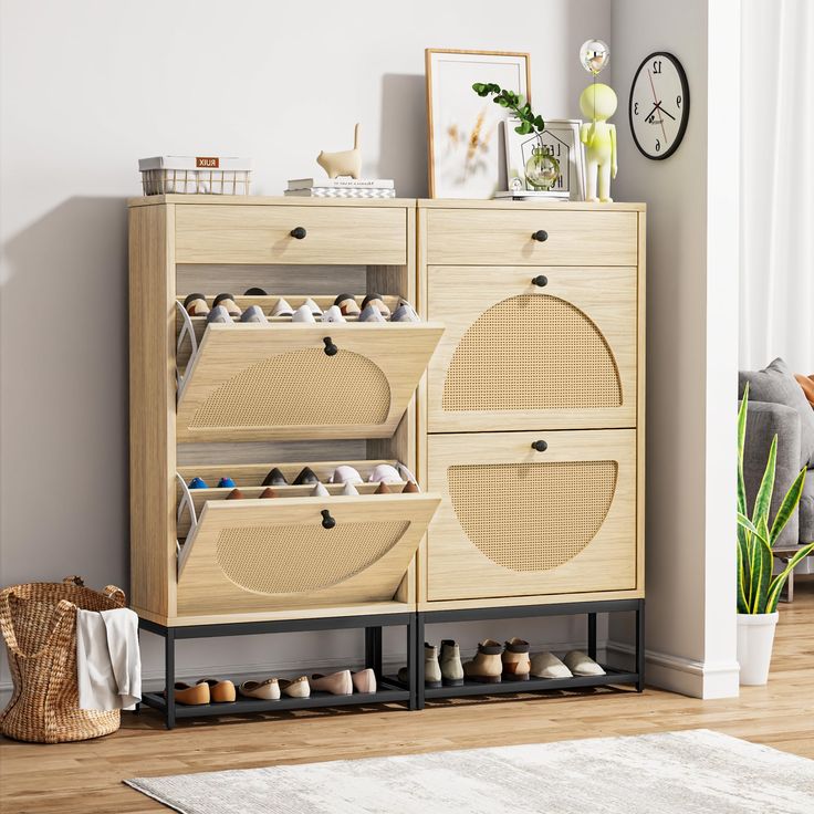 a wooden cabinet with baskets and shoes on it next to a clock, potted plant and other items